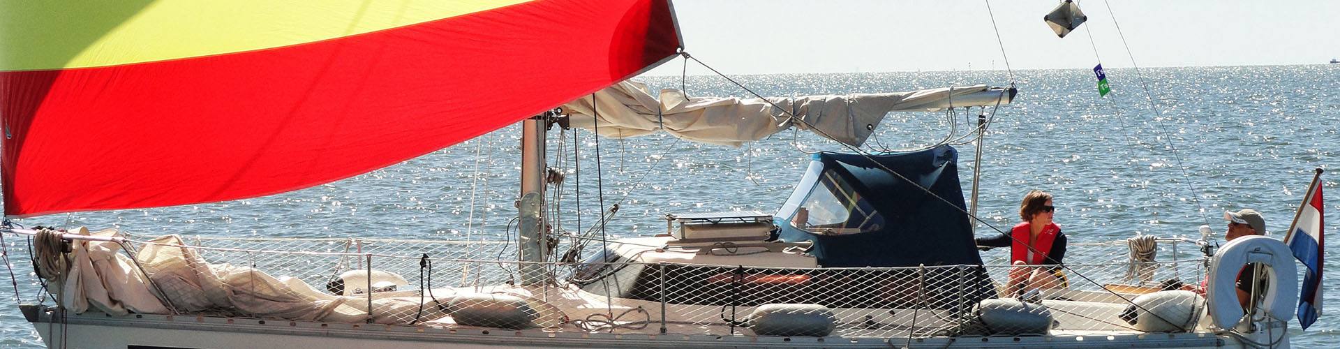 Een zeilboot met zeilnummer 4586 helt over bij een rode ton, op schuimend water
